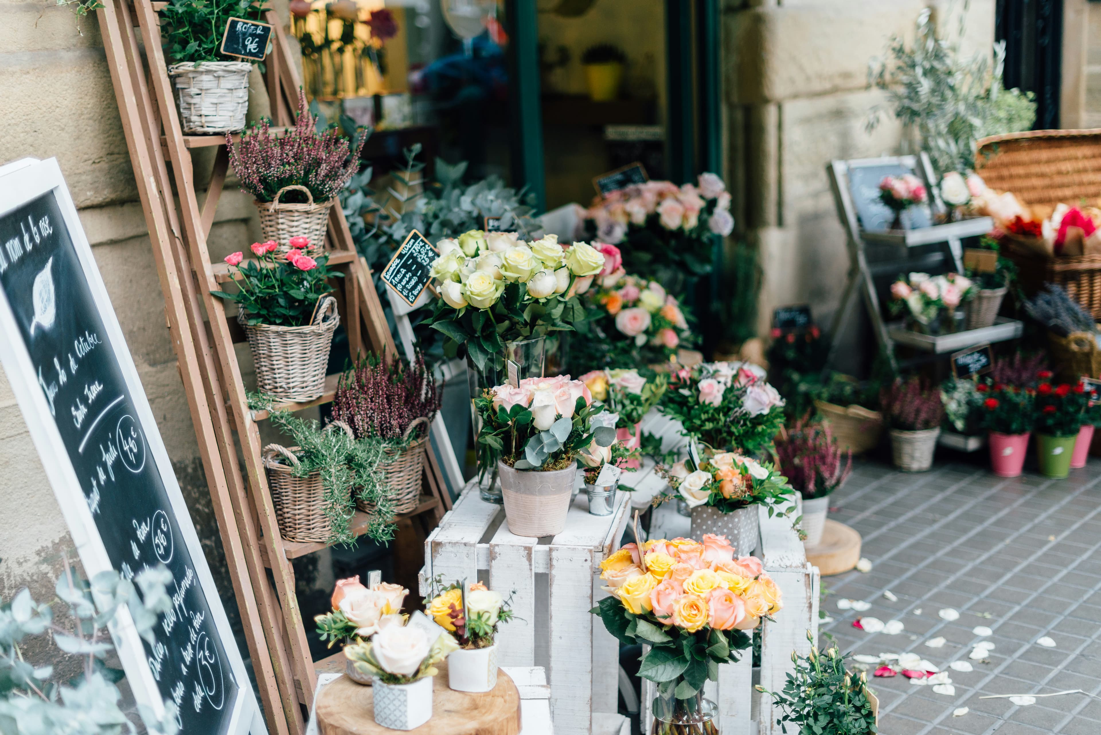 Fachada de uma floricultura com baldes de flores na calçada