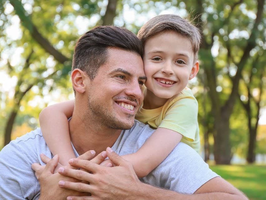 Pai e filho abraçados ao ar livre